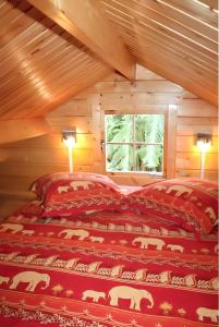a bedroom with a bed in a log cabin at Bungalow charmant à Saint-Joseph, vue sur la piscine in Saint-Joseph