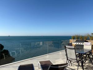 a balcony with a table and chairs and the ocean at Seaside Resort in Trieste