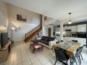 sala de estar y cocina con mesa y sofá en Duplex villa 2, en Pau