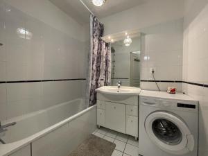 Un baño con lavadora y lavabo. en Duplex villa 2, en Pau 41 fotos más