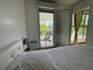 1 dormitorio con 1 cama y balcón con silla en Duplex villa 2, en Pau