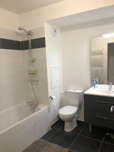 Un baño con inodoro, bañera y lavabo. en Magellan, en Colombes