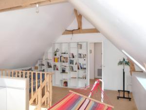 a attic room with a book shelf and a hammock at Charmante maison près de Pénestin avec jardin et terrasse in Pénestin