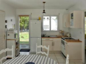 a kitchen with white appliances and a table and chairs at Charmante maison près de Pénestin avec jardin et terrasse in Pénestin