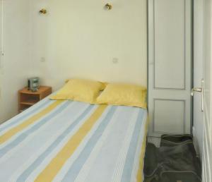 a bed in a room with a door and a bag at Charmante maison près de Pénestin avec jardin et terrasse in Pénestin