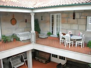 a balcony with a table and chairs on a house at Comfortable house with mountain view and shared pool in Pedraça