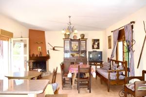 a living room with a table and chairs and a tv at Charming house with mountain view in Siles + Garden in Siles