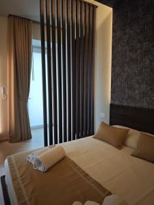 a bedroom with a large bed and a large window at Shanti Rooms & Apartments Castello in Bacoli