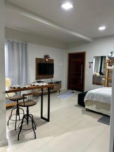 a bedroom with a bed and a desk and a television at Casa Copacabana 2 in Urubici