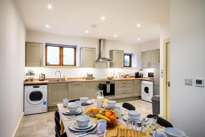 a kitchen with a table with a bowl of fruit on it at Bluebell Barn I Hot Tub I Games Room I Pets Welcome in Preesgreen