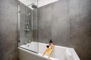 a bathroom with a tub and a shower and a sink at Bluebell Barn I Hot Tub I Games Room I Pets Welcome in Preesgreen +59 photos