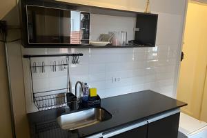a kitchen with a sink and a microwave at Studiohaus Alvorada in São Paulo