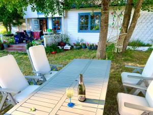 a bottle of champagne sitting on a picnic table with two chairs at Underbart litet hus i lantligt läge in Hemse