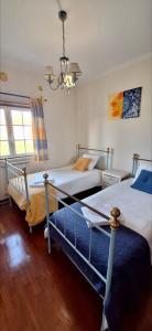 a bedroom with two beds and a chandelier at Casa Terraço in São Bernardino