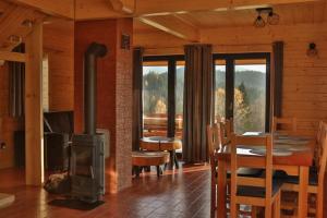 a living room with a wood stove and a table at Domki 15 szczytów in Zawoja