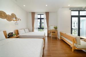 a hotel room with two beds and a couch at Aqua Vista Phu Quoc in Phú Quốc