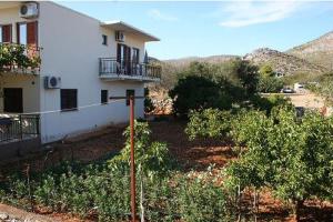 a white house with a balcony on the side of it at Apartments Gordana in Trogir