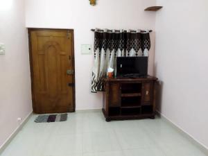 a living room with a door and a television at Adb's Arudhra Homes in Tiruchirappalli