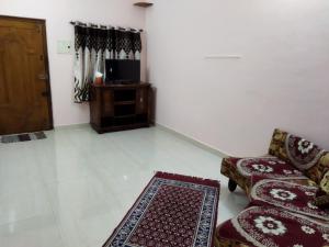 a living room with a couch and a tv and a rug at Adb's Arudhra Homes in Tiruchirappalli +4 photos
