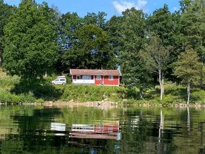 a red house on the shore of a lake at Joarsbo, Stuga 1, Sjölyckan in Kalv