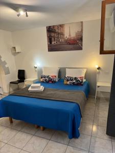 Un dormitorio con una cama azul en una habitación. en LOGIS Hôtel Restaurant La Chaumière, en Marseillan