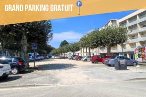 a parking lot with cars parked next to a building at T2 calme 5 min gare, centre, parking gratuit in Dax