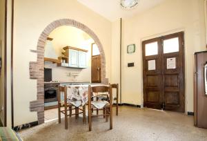 a kitchen with an archway and a table and chairs at Charming Apartment in Massa Marittima, Shared Pool in Massa Marittima
