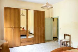a bedroom with a large wooden closet with a mirror at Charming Apartment in Massa Marittima, Shared Pool in Massa Marittima