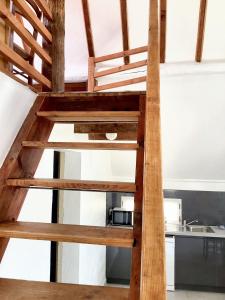 una scala in legno che conduce a una cucina con forno a microonde di Maison conviviale avec jardin à Saint-Nazaire-de-Pézan a Saint-Nazaire-de-Pézan Altre 13 foto