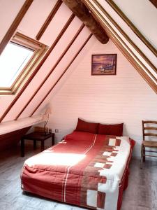 una camera da letto con letto rosso in mansarda di Maison conviviale avec jardin à Saint-Nazaire-de-Pézan a Saint-Nazaire-de-Pézan