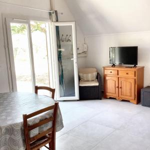 una sala da pranzo con un tavolo e una tv di Maison conviviale avec jardin à Saint-Nazaire-de-Pézan a Saint-Nazaire-de-Pézan