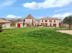 ein großer Rasenhof mit zwei Gebäuden im Hintergrund in der Unterkunft Grande Villa à Villeneuve-sur-Lot avec Piscine Privée in Villeneuve-sur-Lot