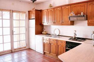 een keuken met houten kasten en een spoelbak bij Charming House in Castilblanco with Terrace and Fireplace in Castilblanco