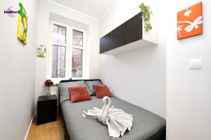 a small bedroom with a bed with red pillows at MMRent Mystic Room in Gdańsk