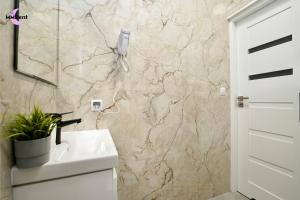 a bathroom with a sink and a stone wall at MMRent Mystic Room in Gdańsk +15 photos