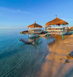 a beach with two huts on the water at Ghar el melh in Ghār al Milḩ