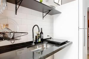 a kitchen with a sink and a laptop on a counter at Studiohaus Pertence in Sao Paulo +75 photos
