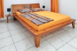a wooden bed with cushions on it in a room at Maison confortable à Port-Louis + Proximité plages in Port-Louis