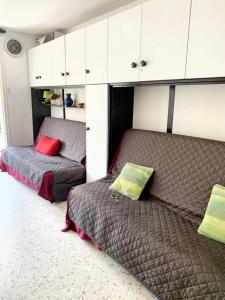 ein Schlafzimmer mit zwei Betten und weißen Schränken in der Unterkunft Studio charmant & lumineux à La Grande-Motte - 22 m² + Balcon in La Grande-Motte