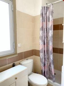 ein Badezimmer mit Toilette und Duschvorhang in der Unterkunft Studio charmant & lumineux à La Grande-Motte - 22 m² + Balcon in La Grande-Motte
