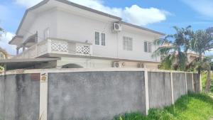 a white house with a fence in front of it at Paradisiacal Villa in Grand Baie with Private Pool in Grand Baie