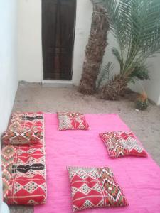 a group of pillows sitting on a pink blanket at Beit Talal 2 بيت طلال in Dahab