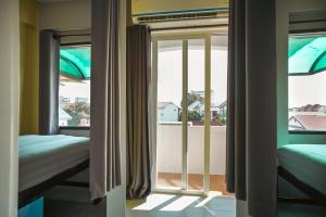 ein Zimmer mit zwei Betten und einem Fenster in der Unterkunft Stamps Backpackers in Chiang Mai