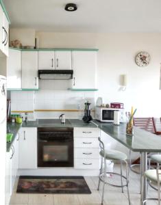 Una cocina con gabinetes blancos y una mesa con sillas. en Cozy apartment in San Sebastián, 44 m² with sea view, en San Sebastián de la Gomera