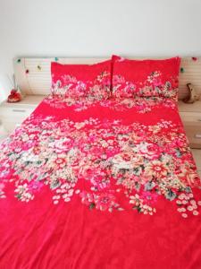 Una cama roja con un ramo de flores. en Cozy apartment in San Sebastián, 44 m² with sea view, en San Sebastián de la Gomera