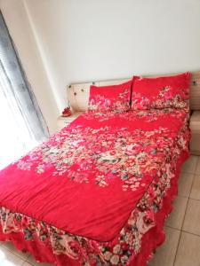 Una cama con una colcha roja con flores. en Cozy apartment in San Sebastián, 44 m² with sea view, en San Sebastián de la Gomera