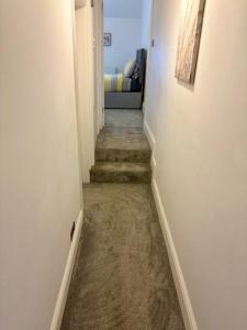 un pasillo con escaleras que conducen a un dormitorio en Charming 2BR House in the Heart of Colwyn Bay, en Colwyn Bay