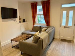 una sala de estar con un sofá y una mesa en Charming 2BR House in the Heart of Colwyn Bay, en Colwyn Bay 3 fotos más