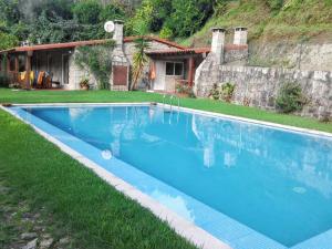 una grande piscina blu davanti a una casa di Elegant Villa with Panoramic Views in Caniçada a Caniçada