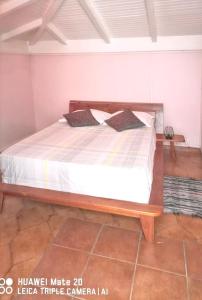 Appartement confortable avec vue sur mer à Deshaies, 48 m² في ديساي: سرير في غرفه مرتبه بيضاء